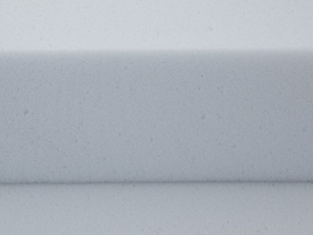Primer plano de la espuma de melamina Basotect G+ gris claro - un canto cortado con la estructura de celda abierta visible