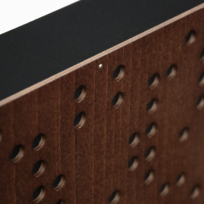 Detalle de la esquina del Difusor Binario - frente Mahogany, perforación y tejido tapizado negro